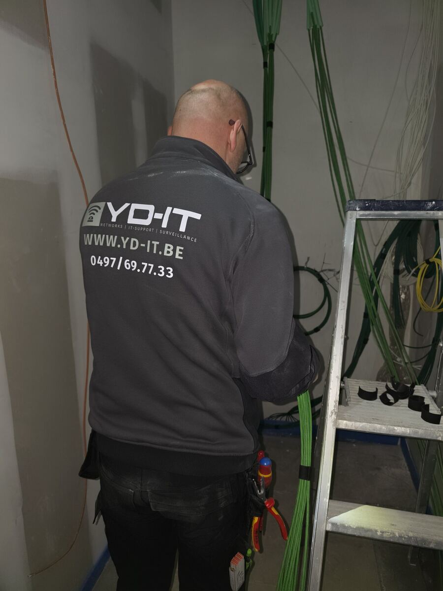 Installateur van YD-IT trekt netwerkkabels op een werf