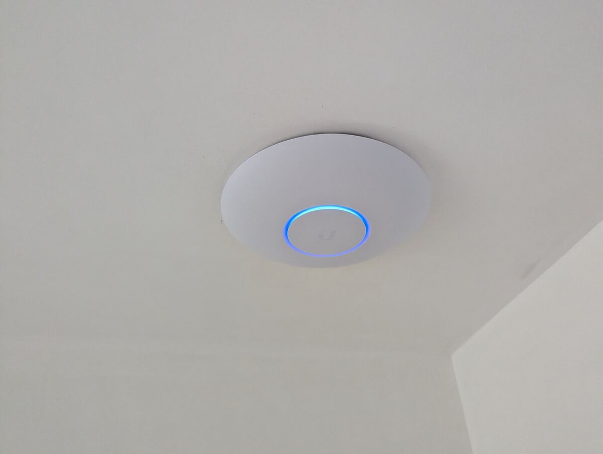 UniFi access point aan het plafond met blauwe statusring