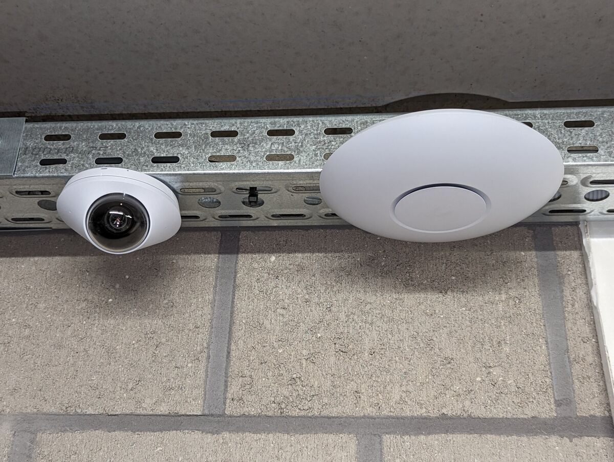 UniFi-camera en access point op een kabelgoot in een bedrijfsruimte