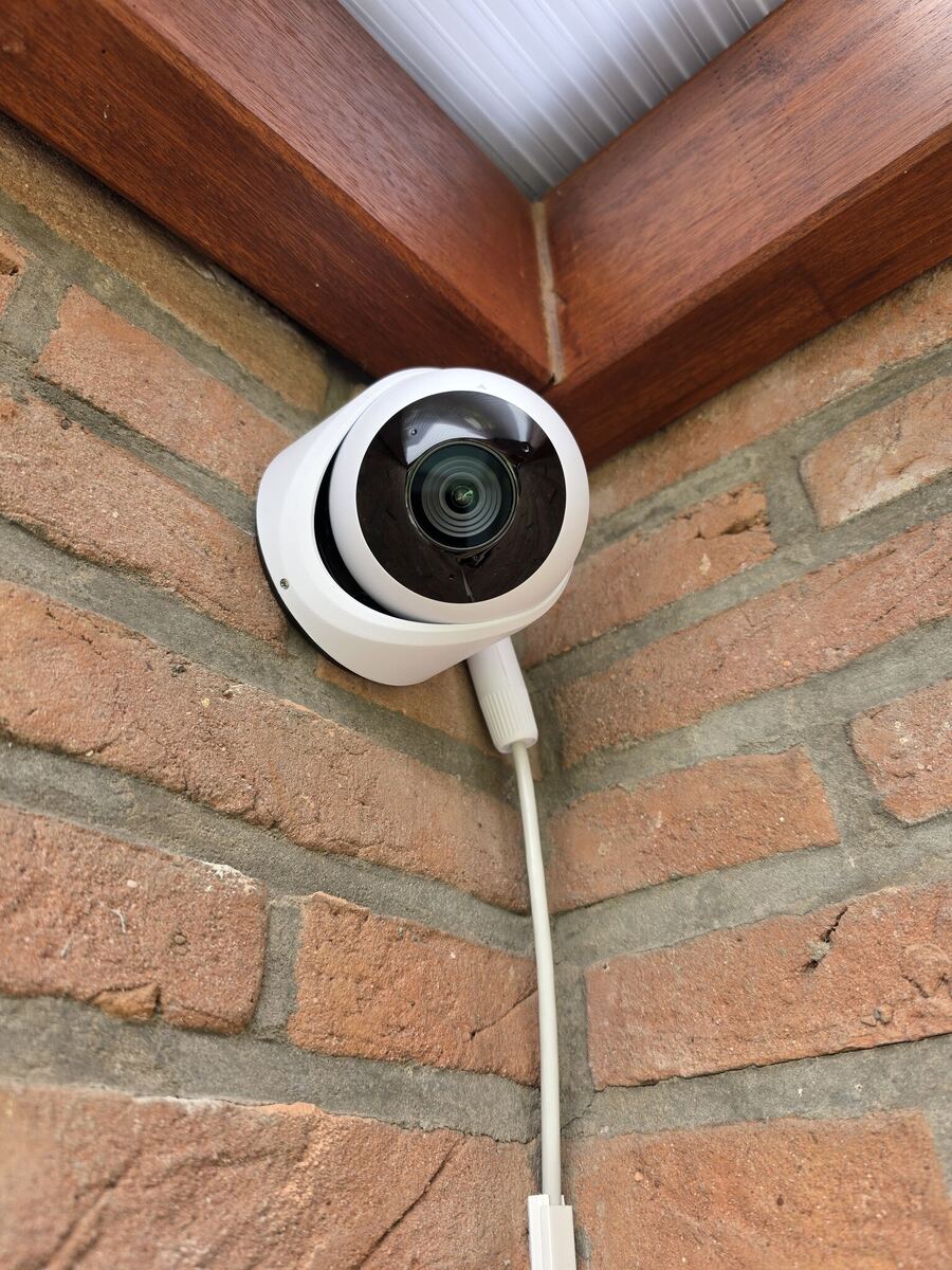 UniFi dome-camera in de hoek van een bakstenen gevel